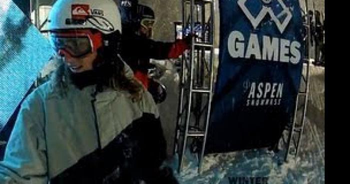 Une snowboardeuse, en essayent de faire un double back sur un big a …