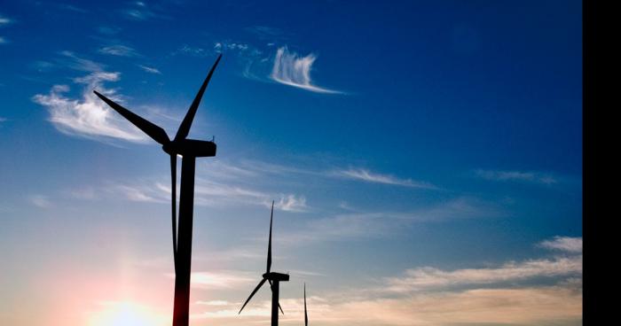 Un homme installe une éolienne sans grue